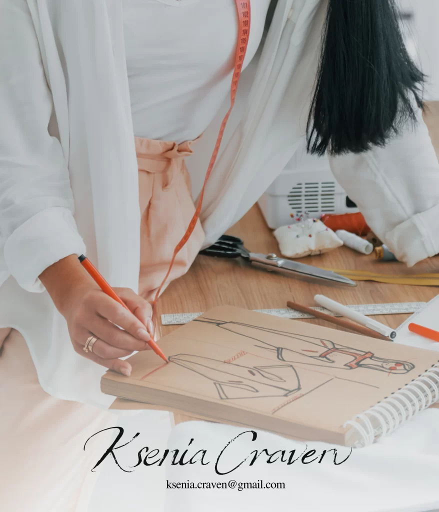 Fashion designer sketching a garment on brown paper with a red marker among sewing tools and measuring tape.